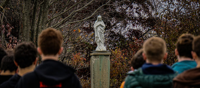 students pray at Mary statue