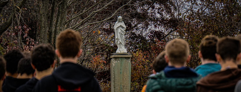 students pray at Mary statue